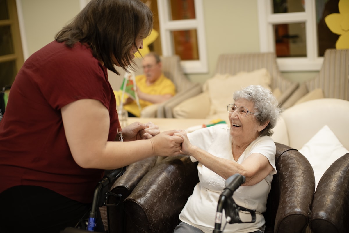 A caregiver assisting an elderly woman using a walker