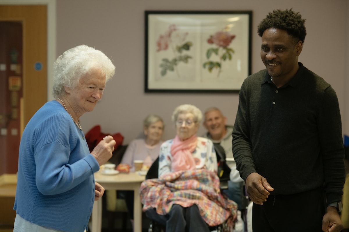 Older adults and a caregiver together in a shared common room