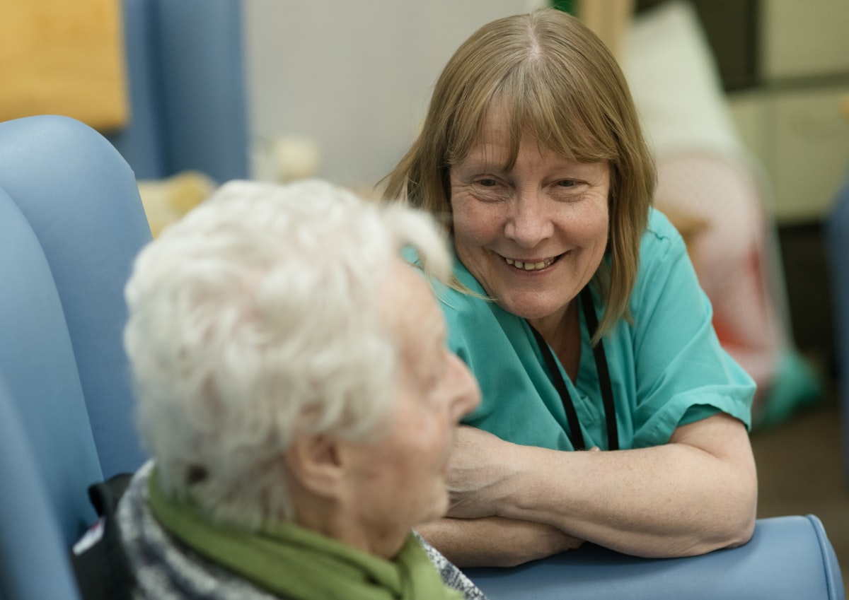 Two people talking together in comfortable chairs while coordinating care