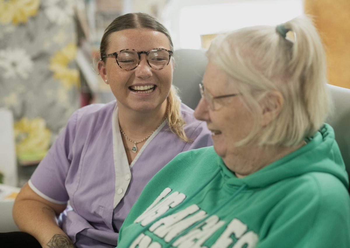 Two people laughing warmly together indoors